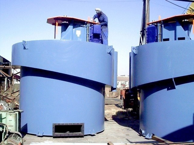 Large blue flotation cell tank with a worker on top during site installation